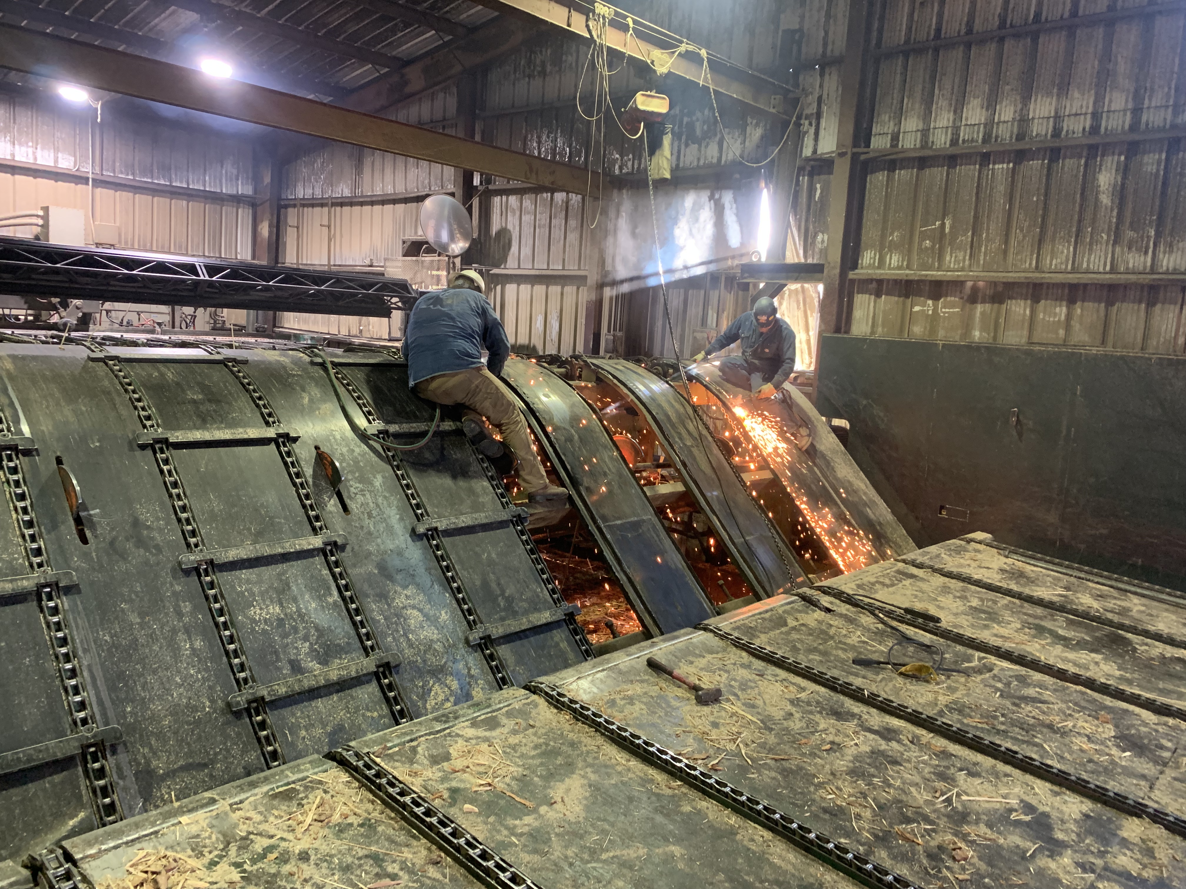 Welding work on large industrial tank inside shop